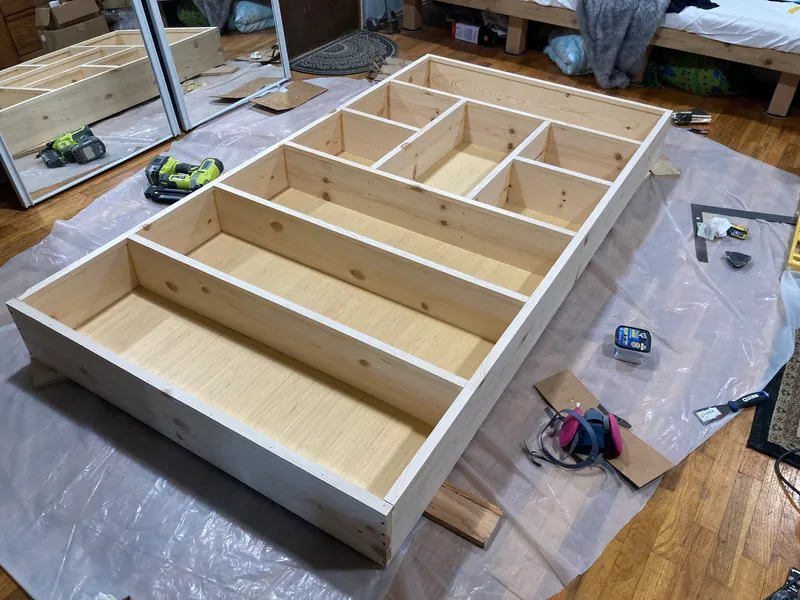 Bookcase frame with cubbies being assembled on plastic sheeting
