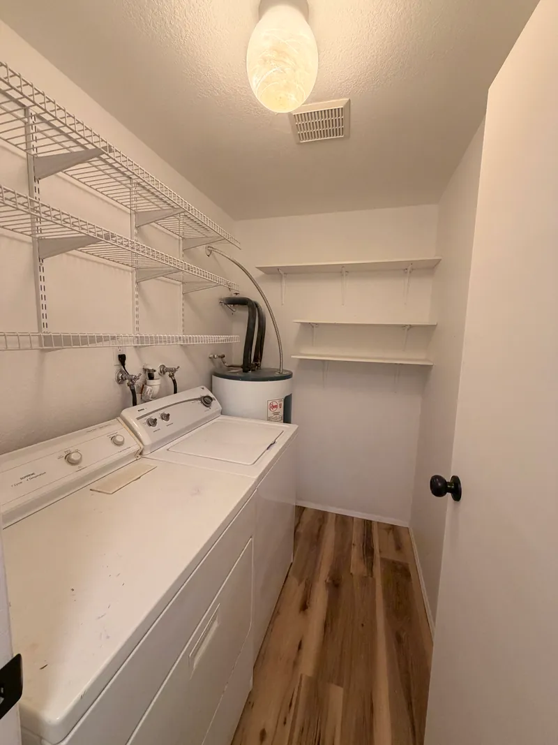 Laundry closet with new plank flooring, fresh walls and an updated ceiling light
